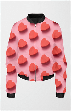 A pink bomber jacket for women with a design of red, three-dimensional hearts scattered across. The jacket has a black collar, cuffs, and hem.