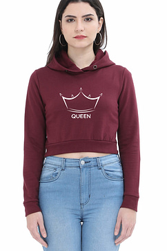 A person wearing a maroon crop hoodie with a crown graphic and the word QUEEN on the front, paired with light blue jeans, stands against a plain white background.