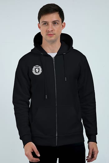 A person wears the Unisex Zip Hoodie - Comfort Meets Style, a black zip-up with a crest on the left, drawstrings, and front pockets, against a plain light-colored background showcasing its sleek looga style.