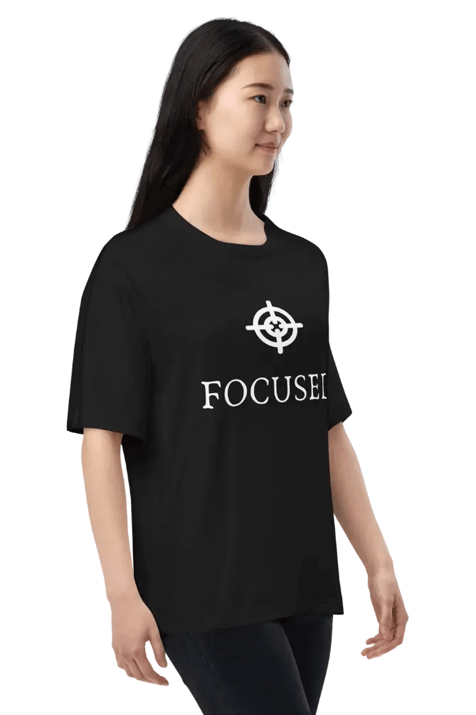 Chic black t-shirt with ‘FOCUSED’ logo and text design on a model.