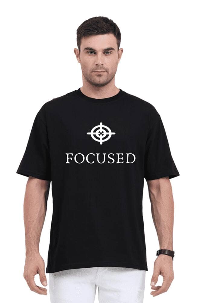 A person wearing the Unisex Oversized T Shirt from Looga, featuring the word FOCUSED and a target symbol, stands confidently against a plain white background. With short dark hair, they exude an aura of tranquility, embodying the spirit of Looga in every fiber.