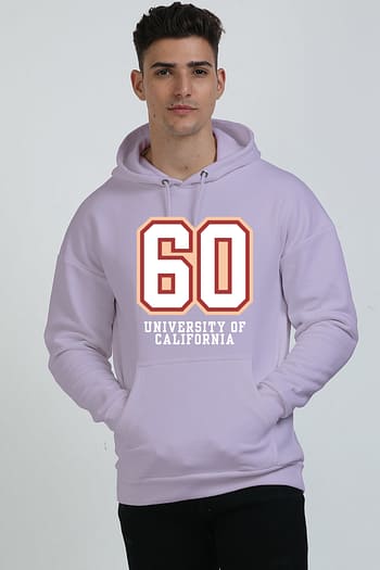 Wearing a stylish Lavender hoodie with 60 and University of California on the front, a person with short dark hair confidently stands against a plain background, effortlessly showcasing the perfect mix of heavyweight hoodies and style.