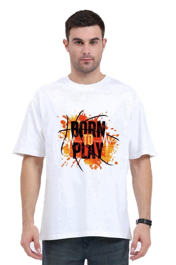 A person wearing an oversized unisex t-shirt from Looga, featuring an orange and black "Born to Play" graphic. The design includes abstract splashes and basketball elements, making a bold statement against the plain white backdrop. A person wearing an oversized unisex t-shirt from Looga, featuring an orange and black "Born to Play" graphic. The design includes abstract splashes and basketball elements, making a bold statement against the plain white backdrop.